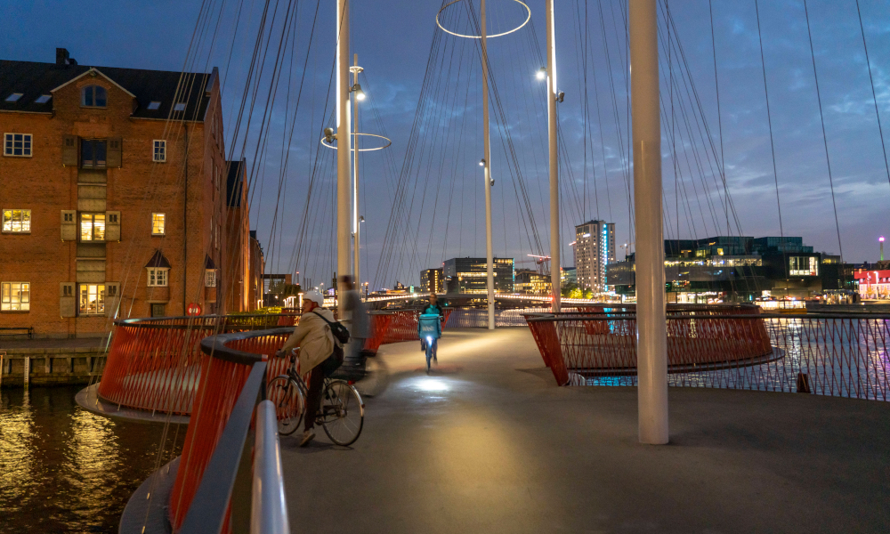 Climate Cruch Team: Eine beleuteter Radweg in Kopenhagen am Abend.