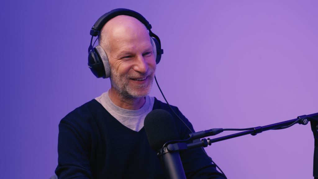 Sebastian Conrad sitzt lächelnd im Podcaststudio.